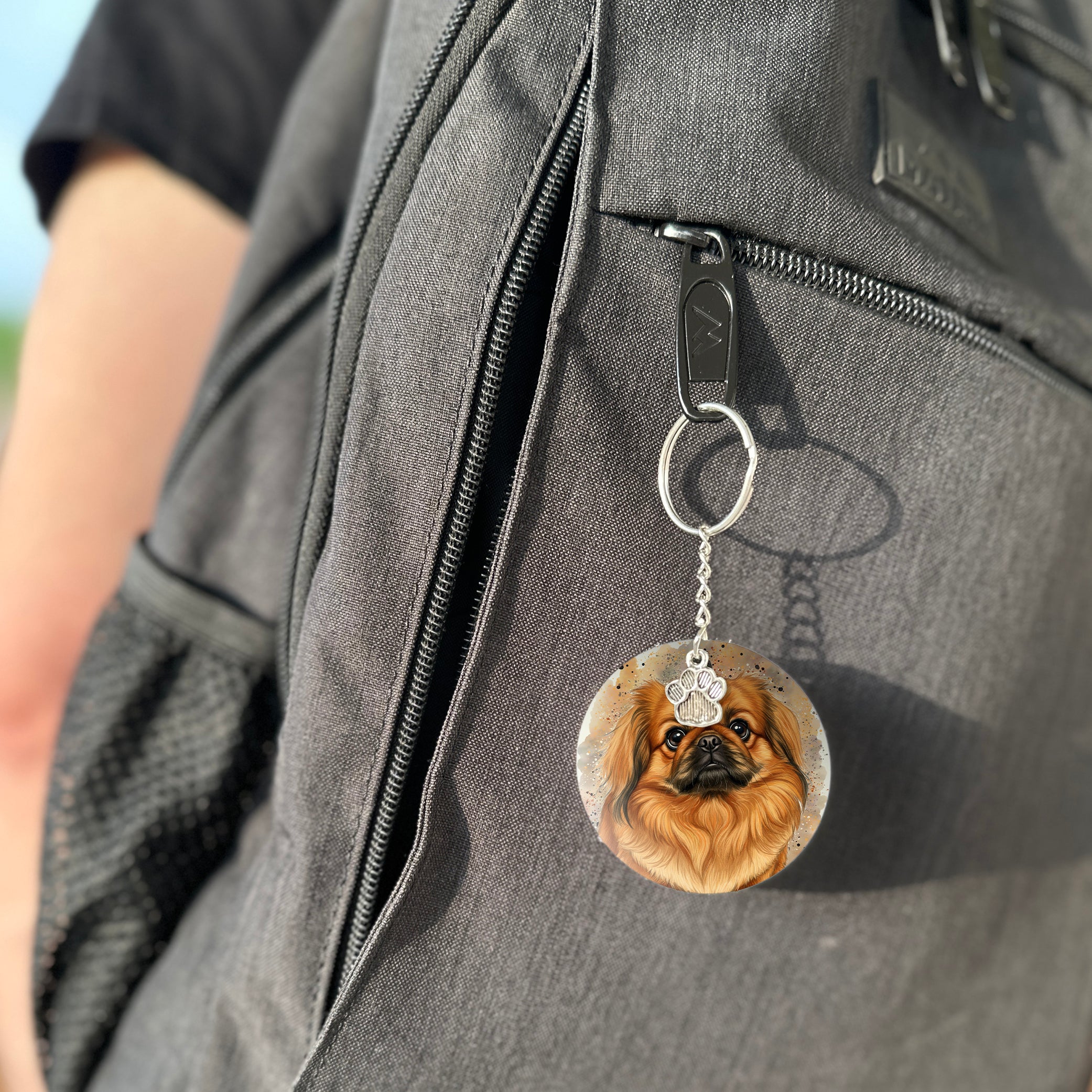 Keychain with a dog's face attached to a gray bag