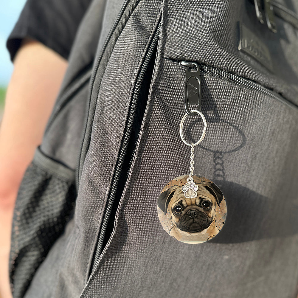 Keychain with a dog's face attached to a gray bag